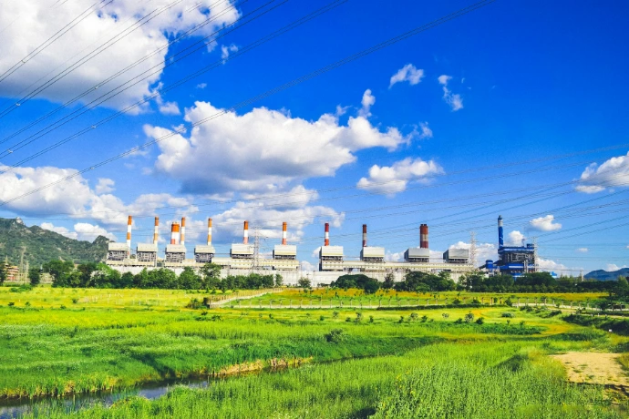 a power plant in the middle of a green field